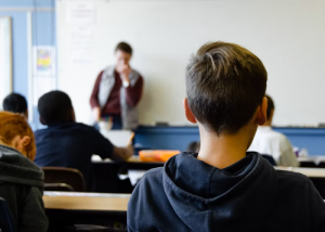 Teacher talking with a student from behind in a classroom